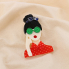 Broche fantaisie Femme aux lunettes vertes résine métal 0525028 rouge